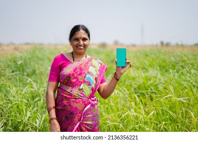 Happy Smiling Indian Woman Farmer Showing Green Screen Mobile Phone In Front Of Green Farmland - Concept Of App Advertisement And Farm Product Promotion.