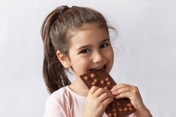 Happy Smiling Kid Girl Biting Tasty Chocolate With Empty Copy Space. Isolated Portrait
