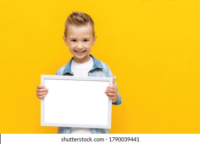 Happy Smiling Kid Holding White Frame With Copy Space For Text Certificate Or Diploma