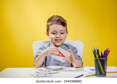 Happy Smiling Little Preschool Boy Shows Letters At Home Making Homework At The Morning Before The School Starts. English Learning For Kids.
