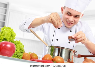 happy smiling male chef cooking in the kitchen - Powered by Shutterstock