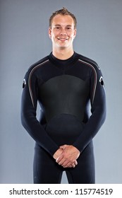 Happy Smiling Man With Short Hair Wearing Wetsuit. Kite Surfer. Studio Shot. Isolated On Grey Background.