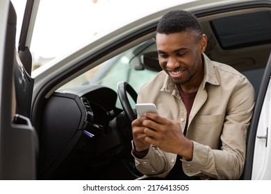 Happy Smiling Man Typing A Message On The Phone While Sitting In The Car.