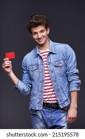 Happy Smiling Man Wearing Denim Jacket Showing Showing Blank Paper Card Sign With Copy Space For Text, Over Gray Background