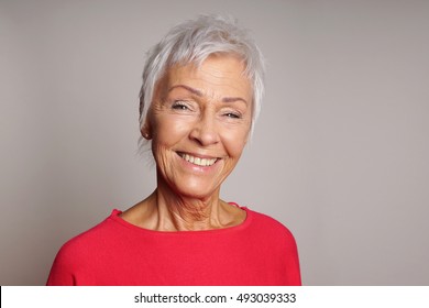 happy smiling mature woman in her sixties with trendy white short hair