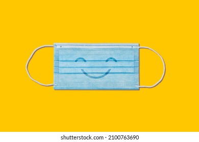 Happy Smiling Medical Face Mask On Yellow Background.