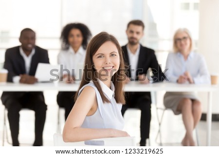 Happy smiling millennial applicant looking at camera at job interview with hr group, successful excited satisfied woman vacancy candidate portrait, make good first impression, getting hired concept