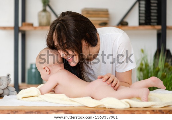 笑顔の母親が裸の幼い女の子を抱きしめる の写真素材 今すぐ編集