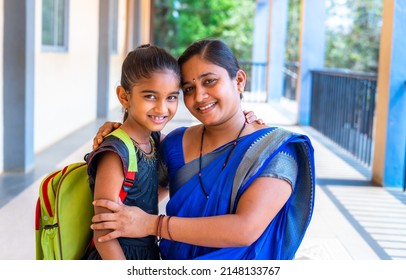 happy smiling Mother embracing her daughter before going to classrrom at school corridor by looking at camera - concept of back to school, relationship and parental love