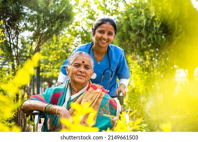 happy smiling Nurse taking senior woman on walk while on wheelchair at hospital garden by looking at camera - concept of caretaker, disability and healthcare - Powered by Shutterstock