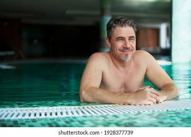 Happy Smiling Older Man Enjoying Indoor Swimming Pool. Concepts Of Spa, Wellness.