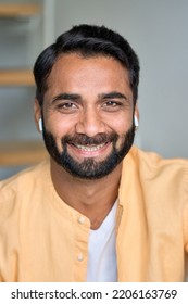 Happy Smiling Positive Handsome Wealthy Bearded Indian Ethnic Man Wearing Eabuds Looking At Camera Feeling Cheerful And Satisfied At Home Indoors. Close Up Front Male Face Vertical Portrait.