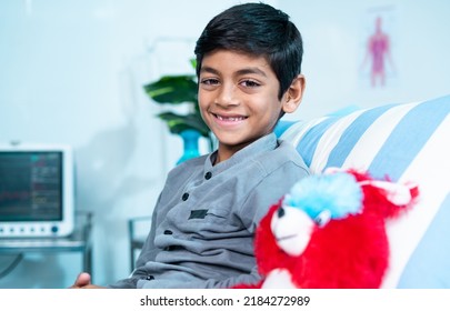 Happy Smiling Recovered Kid With Teddy Bear Looking At Camera At While Admitted At Hospital Ward - Concept Of Mental Health, Successful Treatment And Childcare