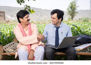Happy smiling  rural indian male farmer hand shake with agronomist or banker use laptop sitting on bed at agriculture field. Deal final, Financial support or farming crop loan benefit - Shutterstock ID 2017059044