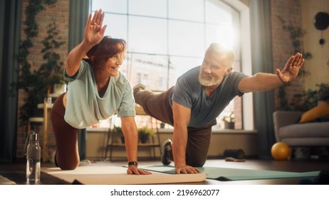 Happy Smiling Senior Couple Doing Gymnastics and Yoga Stretching Exercises Together at Home on Sunny Morning. Concept of Healthy Lifestyle, Fitness, Recreation, Couple Goals, Wellbeing and Retirement. - Powered by Shutterstock