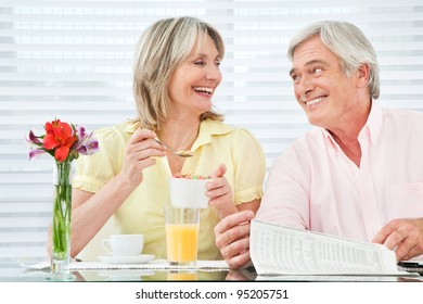 Happy Smiling Senior Couple Eating Breakfast At Home