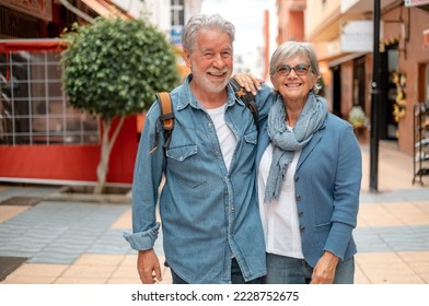 Happy smiling senior couple of tourist walking in the city. Attractive white haired caucasian people enjoying free time or retirement - Shutterstock ID 2228752675