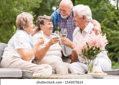 Happy and smiling senior people drinking wine on the terrace during summer - Powered by Shutterstock