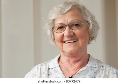 Happy smiling senior woman looking at camera at home