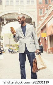 Happy Smiling Shopping Man Texting On His Phone At A Store