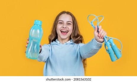 happy smiling teen girl hold sport or fitness equipment of jumping rope and water bottle, refreshment - Powered by Shutterstock