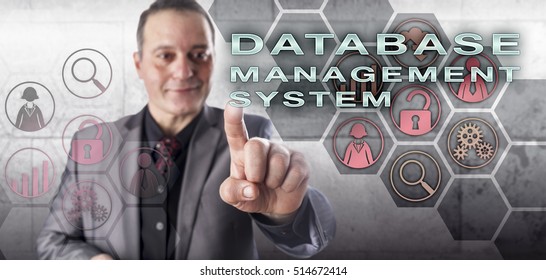 Happy, Smiling, But Uncompromising, Male Database Expert Is Touching DATABASE MANAGEMENT SYSTEM On An Interactive Control Screen. Information Technology Concept And Data Management Metaphor.