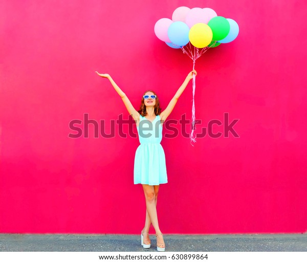ピンクの背景に幸せな笑顔の女性と空のカラフルな風船 の写真素材 今すぐ編集