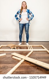 Happy Smiling Woman Assembling Wood Furniture. DIY Enthusiast. Young Girl Doing Home Improvement.