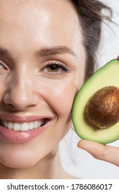 Happy Smiling Woman With Avocado Cropped Studio Portrait. Beautiful Vegetarian Showing Positive Emotion On Face. Proper Nutrition, Raw Food Diet, Ketodiet, Weight Loss. Veganism And Vegetarianism