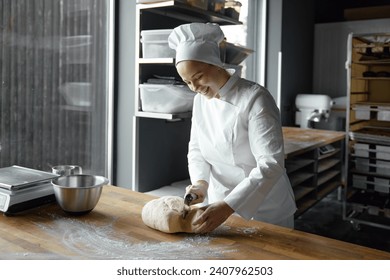 Happy smiling woman baker shaping dough for cooking bread, pizza or pastry - Powered by Shutterstock