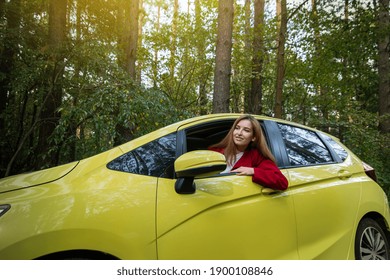 Happy Smiling Woman Driver Wearing Red Coat Sits In The Car