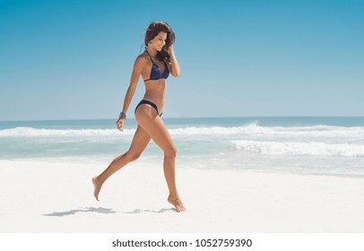 Happy smiling woman jumping on the beach. Beautiful young woman running on tropical beach. Happy latin girl walking on white sand beach during summer vacation with copy space. - Powered by Shutterstock