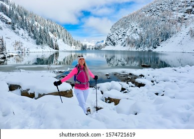 Happy Smiling Woman Snowshoeing In Mountains By Alpine Lake With Reflections. Lake Agnes Tea House Trail In Banff National Park. Canadian Rockies. Alberta. Canada