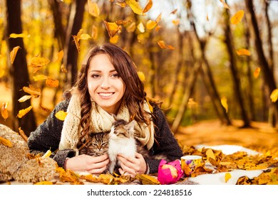 Happy Smiling Woman With Two Cats Under Falling Autumn Leafs