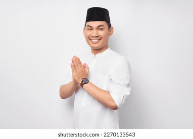 Happy smiling young Asian Muslim man in Arabic costume standing with gesturing Eid Mubarak greeting and welcoming Ramadan isolated on white background. People religious Islamic lifestyle concept - Shutterstock ID 2270133543