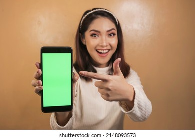 Happy And Smiling Young Asian Women Showing A Green Blank Screen.