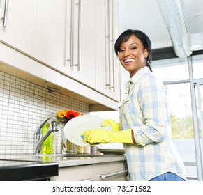 Happy Smiling Young Black Woman Enjoying Washing Dishes In Kitchen