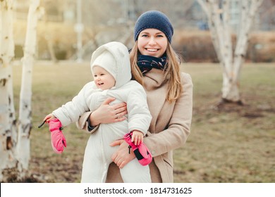 Happy Smiling Young Caucasian Mother Holding Baby Daughter Outdoor. Mothers Day Holiday. Authentic Lifestyle Family With Infant Kid Child. 