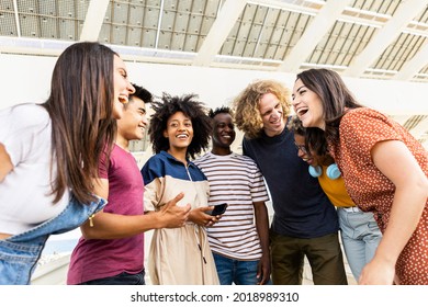 Happy Smiling Young Friends Standing Outdoors In The Street While Laughing And Hanging Out - Multiracial Group Of University Students Having Fun After Classes - Happy Lifestyle And Youth Concept