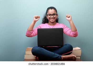 Happy Smiling Young Girl Of Indian Ethnicity With A Laptop Shows Cheering Gesture