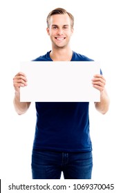 Happy Smiling Young Man Showing Blank Signboard With Empty Copyspace Area For Slogan Or Advertising Text Message, Isolated On White Background. Caucasian Male Model In Advertisiment Concept.