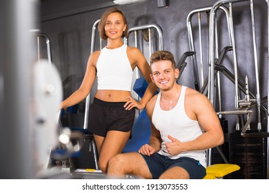 happy smiling young man and woman fitness coaches taking break during workout in gym indoors .