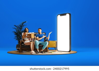 Happy smiling young man and woman, couple sitting couch near giant 3D model of mobile phone with empty screen over blue background. Shopping, presents, sales. Mockup for text, ad, design, logo - Powered by Shutterstock