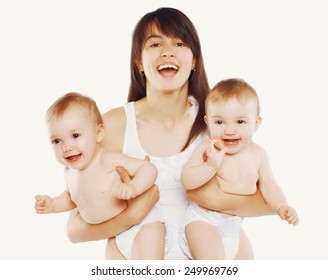 Happy Smiling Young Mother Holding Two Twin Babies On White Background