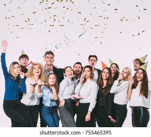 Happy smiling young people with gift boxes and blowing party whistles. Celebration concept. - Powered by Shutterstock