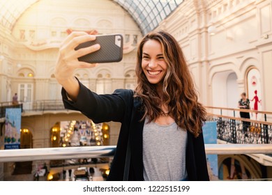 Happy Smiling Young Woman Portrait Taking Selfie Photo Inside Department Store In Moscow.