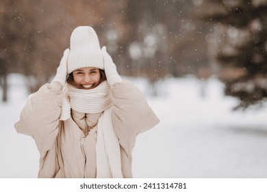 Happy smiling young woman portrait dressed coat scarf hat and mittens enjoys winter weather at snowy winter park - Powered by Shutterstock