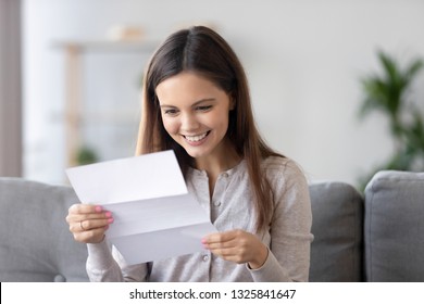 Happy Smiling Young Woman Reading Paper Letter, Receive Good News, Sitting On Sofa At Home, Cheerful Girl Looking At Document, Student With Great Exam Results Notification, Success Concept