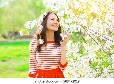 Happy Smiling Young Woman With Spring Flowers At Garden
