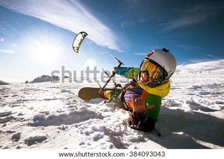 Happy snowboarder with kite lies in snowdrift. Sheregesh resort, Siberia, Russia